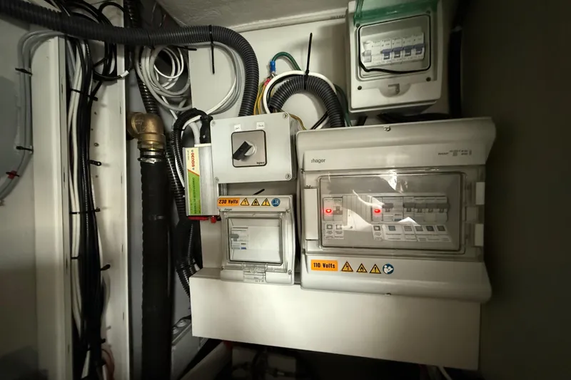 Slide: The Image of Electrical panel on a 2015 Fountaine Pajot Summerland 40 LC boat, showing wiring and switches. - 114