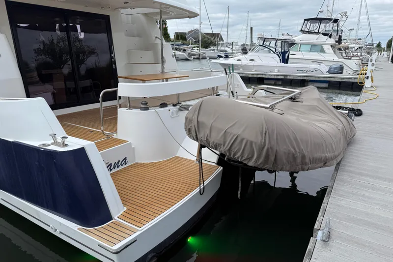 Slide: The Image of 2015 Fountaine Pajot Summerland 40 LC docked, featuring a covered dinghy and spacious deck area. - 14