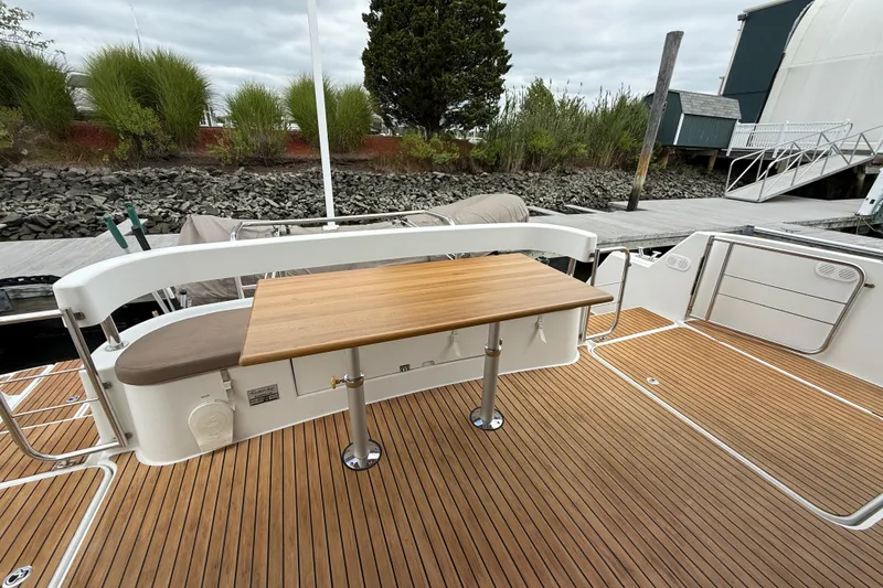 Slide: The Image of 2015 Fountaine Pajot Summerland 40 LC yacht deck with wooden table and seating. - 18
