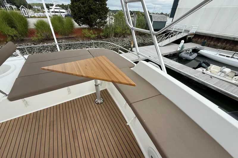 Slide: The Image of 2015 Fountaine Pajot Summerland 40 LC yacht with cushioned seating and wooden table on deck. - 46