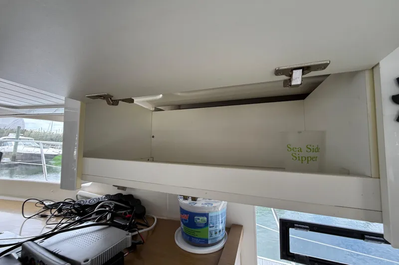 Slide: The Image of Open cabinet on 2015 Fountaine Pajot Summerland 40 LC yacht with "Sea Side Sipper" cup inside. - 68