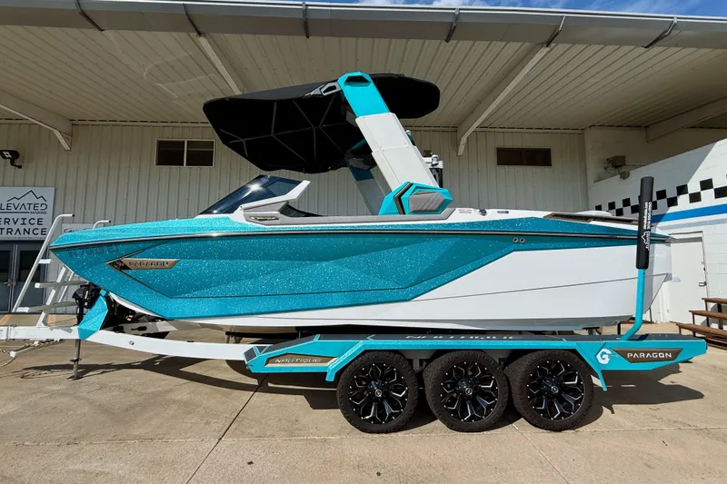 Slide: The Image of 2021 Nautique Super Air Nautique G23 Paragon boat on trailer, vibrant blue and white design. - 0