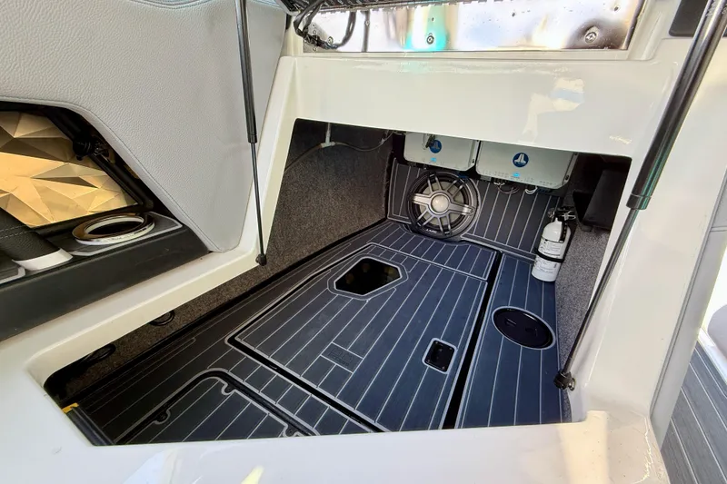 Slide: The Image of 2021 Nautique Super Air Nautique G23 Paragon interior storage compartment with speaker and fire extinguisher. - 29