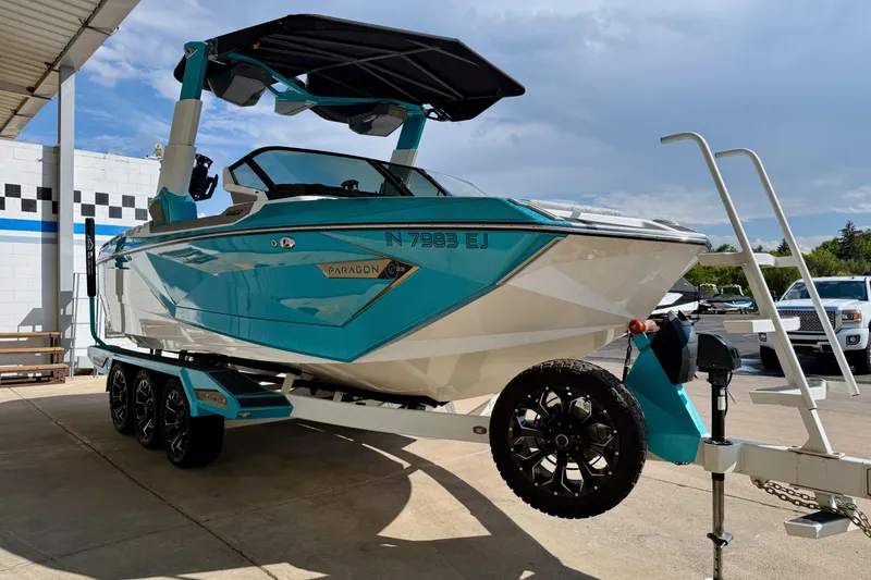 Slide: The Image of 2021 Nautique Super Air Nautique G23 Paragon boat on trailer, vibrant blue and white design. - 8