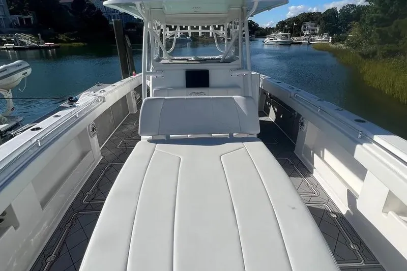 Slide: The Image of 2020 Invincible 40 Catamaran with spacious deck and seating, docked in serene waters. - 16