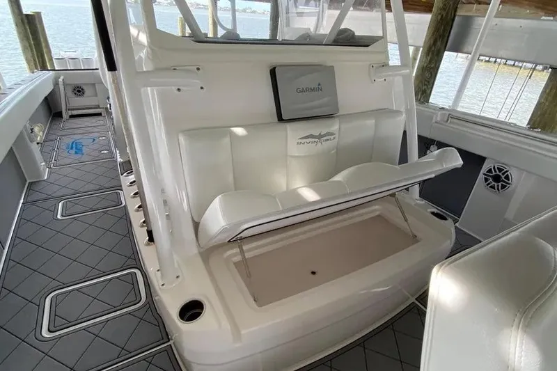 Slide: The Image of 2020 Invincible 40 Catamaran interior with seating and Garmin equipment, docked by the water. - 23