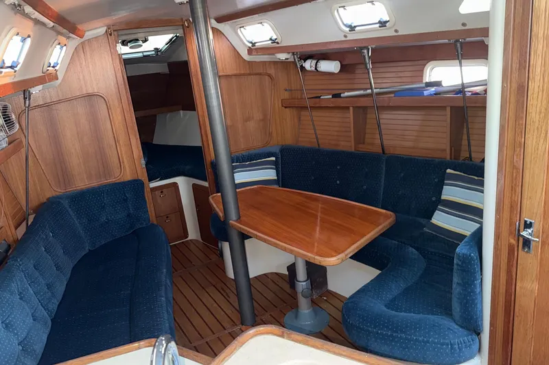 Slide: The Image of Interior of a 1994 Catalina 320 sailboat with cozy seating and wooden table. - 11