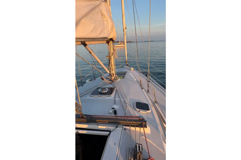 Slide: The Image of Sailing on a 1994 Catalina 320 yacht at sunset, calm waters. - 12