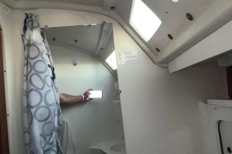 Slide: The Image of Interior of a 1994 Catalina 320 sailboat bathroom with shower curtain and mirror. - 15
