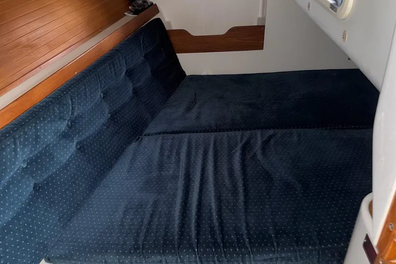 Slide: The Image of Interior cabin of a 1994 Catalina 320 sailboat with blue cushioned seating. - 17