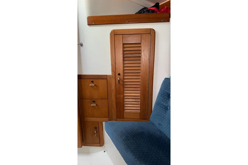 Slide: The Image of Wooden interior of 1994 Catalina 320 sailboat with louvered cabinet and blue cushioned seating. - 18