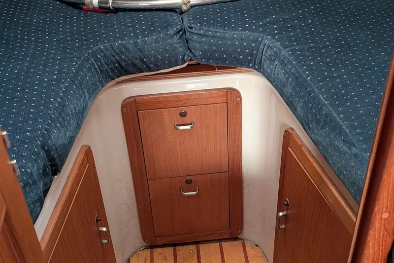 Slide: The Image of Interior cabin of a 1994 Catalina 320 sailboat with blue cushions and wooden storage. - 5