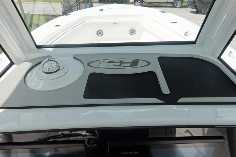 Slide: The Image of 2026 Sea Hunt Gamefish 27 Coffin Box dashboard with compass and Garmin display. - 23