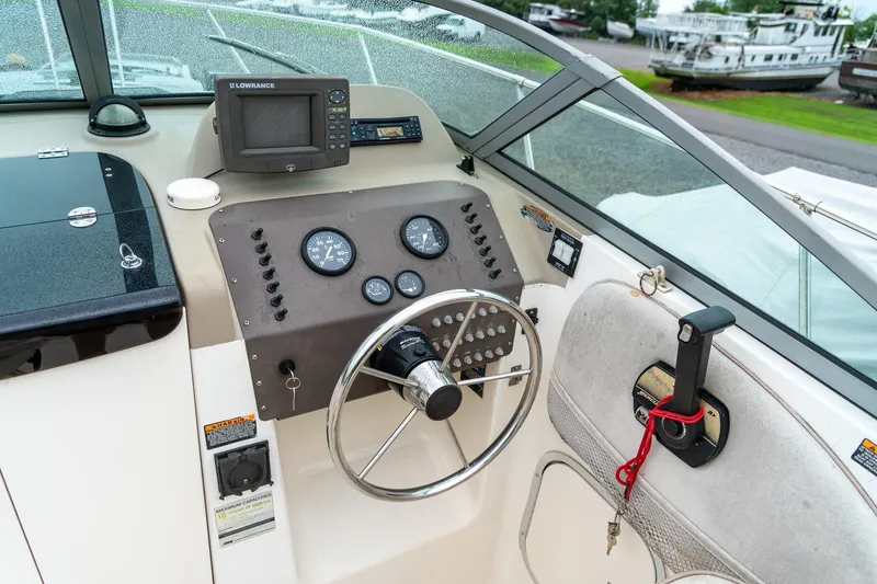 Slide: The Image of 2002 Bayliner 2302 Trophy Walkaround boat dashboard with steering wheel and navigation instruments. - 15