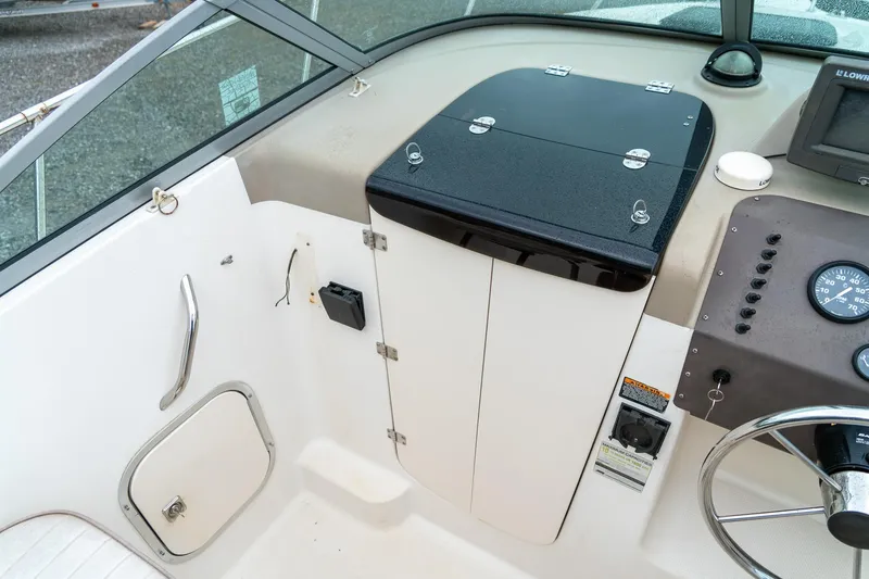Slide: The Image of 2002 Bayliner 2302 Trophy Walkaround boat interior with control panel and storage compartments. - 20