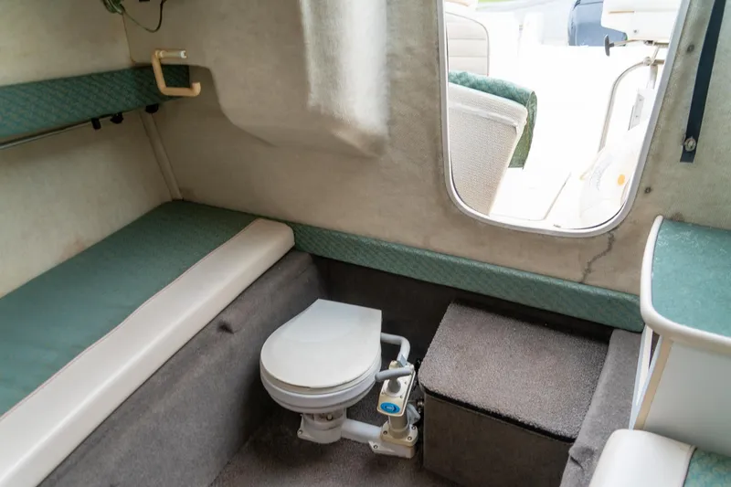 Slide: The Image of 2002 Bayliner 2302 Trophy Walkaround cabin interior with seating and marine toilet. - 25