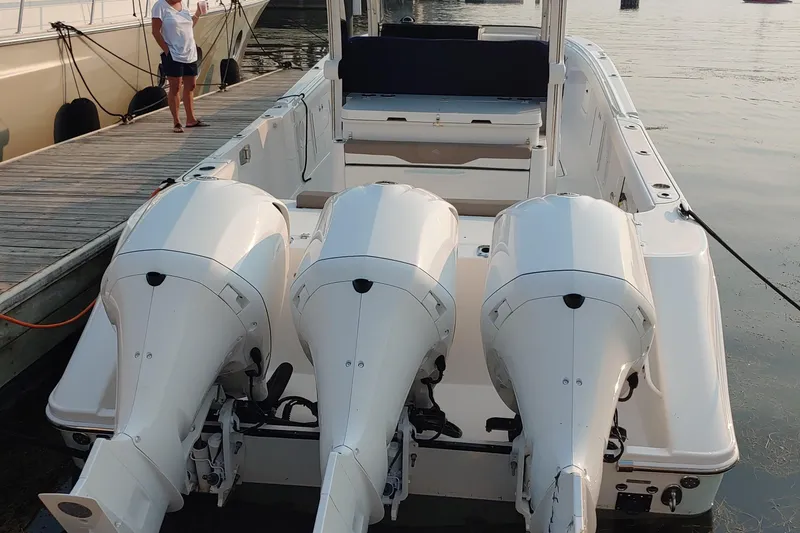 Slide: The Image of 2021 Edgewater 370CC boat with triple outboard engines docked at marina. - 4