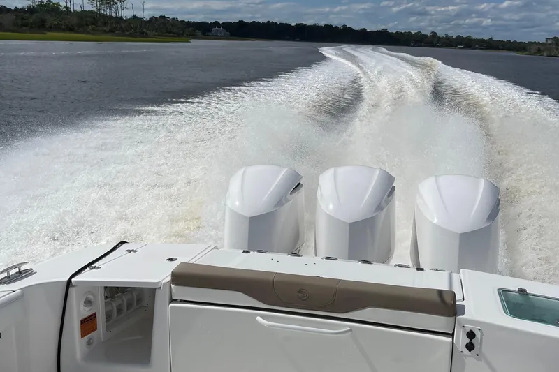 Slide: The Image of 2021 Edgewater 370CC boat with triple engines cruising on open water. - 6