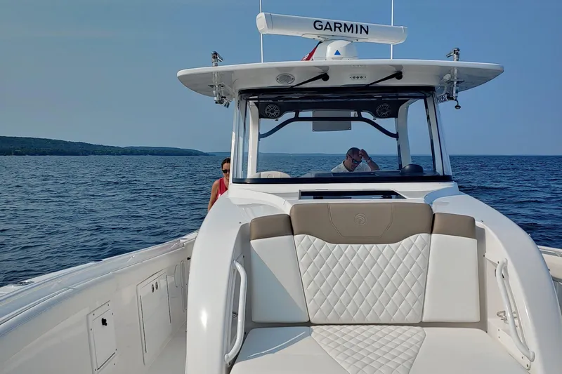 Slide: The Image of 2021 Edgewater 370CC boat cruising on open water with Garmin equipment. - 9