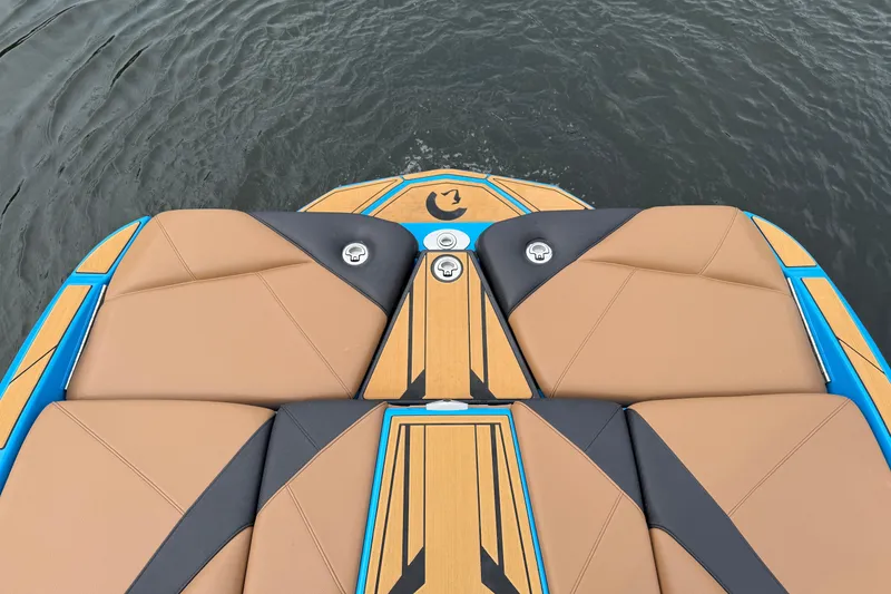 Slide: The Image of 2025 Centurion Nv233 boat deck with tan and black seating, on water. - 12