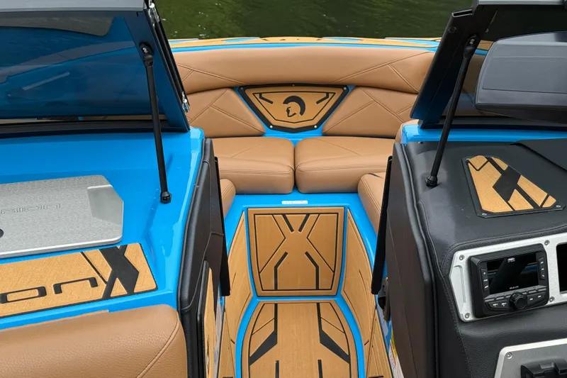 Slide: The Image of 2025 Centurion Nv233 boat interior with tan seating and blue accents. - 6