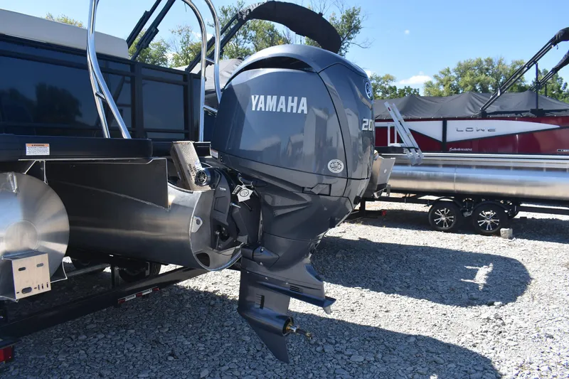 Slide: The Image of 2026 Godfrey Sweetwater 2286C Tritoon with Yamaha outboard motor, parked on gravel. - 6