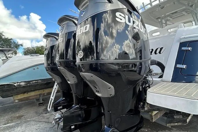 Slide: The Image of Triple Suzuki outboard motors on a 2017 Intrepid boat, reflecting blue sky and clouds. - 14