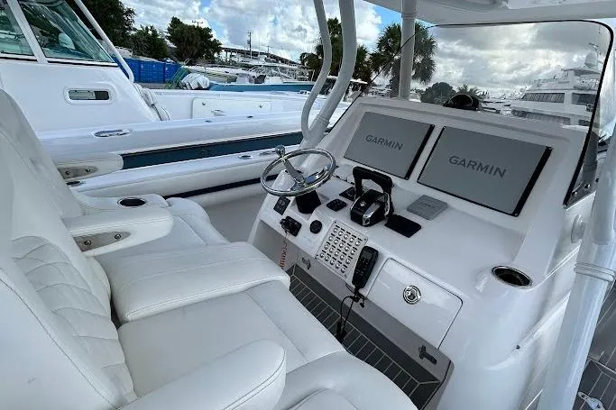 Slide: The Image of 2017 Intrepid boat cockpit with dual Garmin displays and white leather seating. - 7