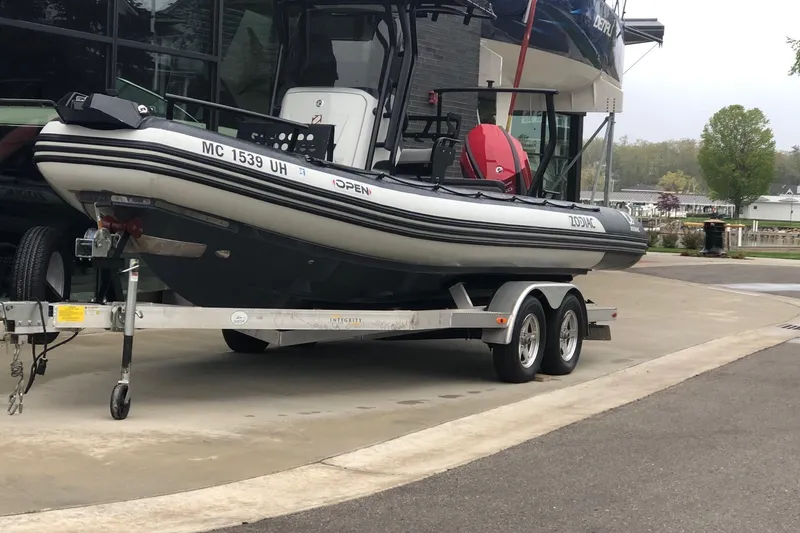 Slide: The Image of 2019 Zodiac Open 7 boat on trailer, parked outdoors near a marina. - 18