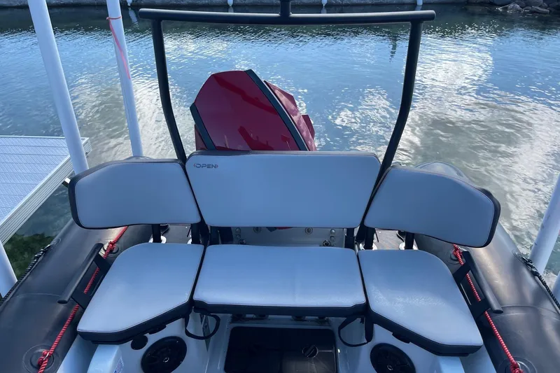 Slide: The Image of 2019 Zodiac Open 7 boat with seating, docked by the water. - 20