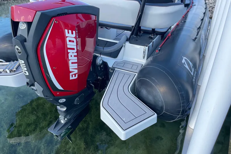 Slide: The Image of 2019 Zodiac Open 7 boat with Evinrude outboard motor, docked on clear water. - 28