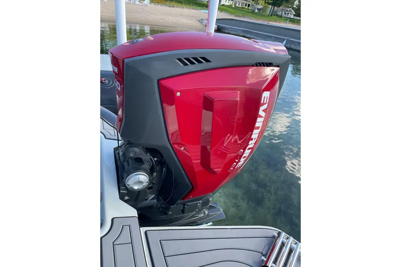Slide: The Image of Red Evinrude outboard motor on 2019 Zodiac Open 7 boat, docked by a sandy shore. - 30