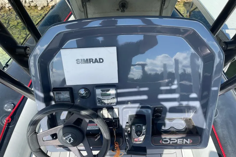 Slide: The Image of 2019 Zodiac Open 7 boat dashboard with Simrad navigation system and steering wheel. - 5