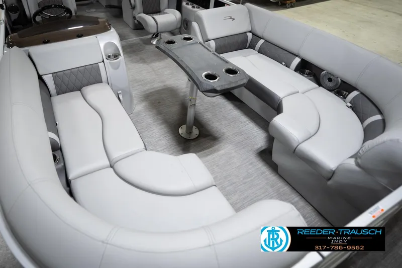 Slide: The Image of 2023 Bennington 22 LSR boat interior with luxurious seating and table, Reeder Trausch Marine logo. - 12