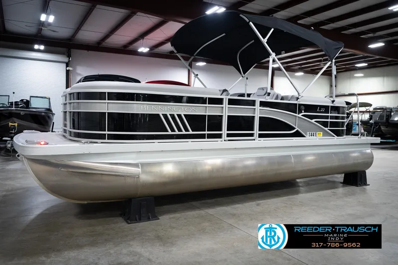 Slide: The Image of 2023 Bennington 22 LSR pontoon boat in showroom with black canopy. - 3