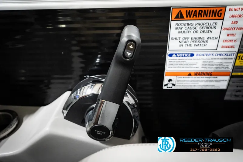 Slide: The Image of Throttle control and warning labels on a 2023 Bennington 22 LSR boat dashboard. - 37