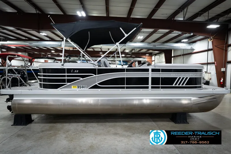 Slide: The Image of 2023 Bennington 22 LSR pontoon boat in showroom, side view, black and silver design. - 6