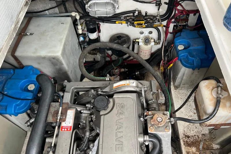 Slide: The Image of Engine compartment of a 2005 Legacy Yachts 28, showcasing mechanical components and wiring. - 12