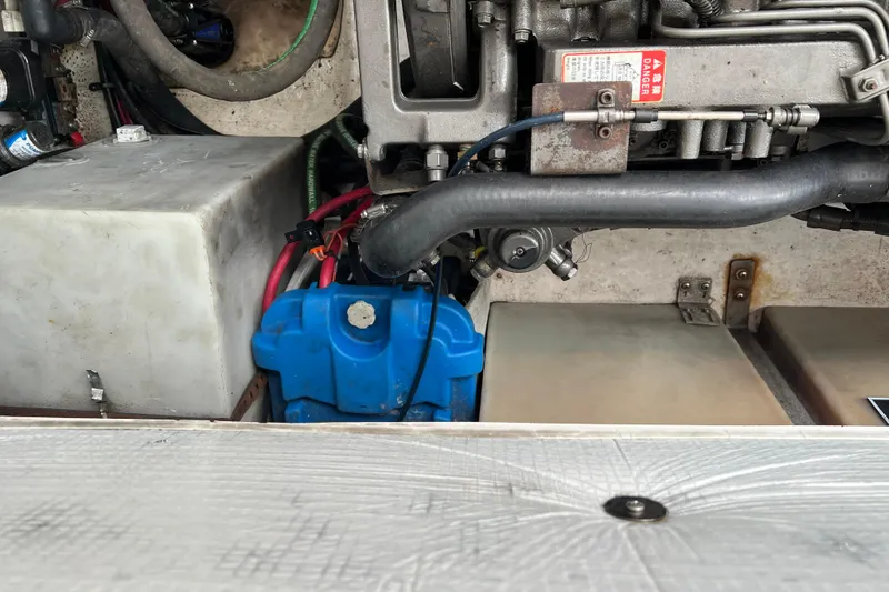 Slide: The Image of Engine compartment of a 2005 Legacy Yachts 28, featuring mechanical components and wiring. - 13