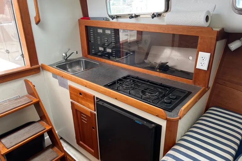 Slide: The Image of 2005 Legacy Yachts 28 interior kitchen with sink, stove, and compact fridge. - 14