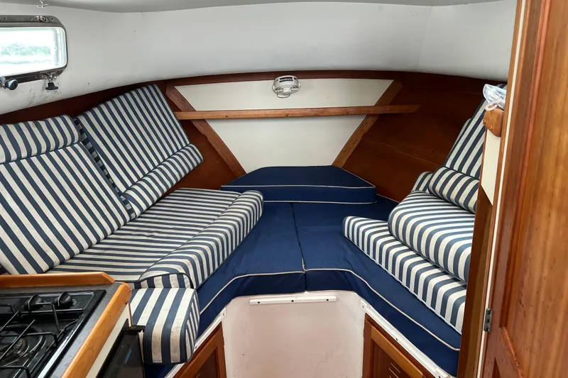 Slide: The Image of Interior of 2005 Legacy Yachts 28 with striped cushions and wooden accents. - 17