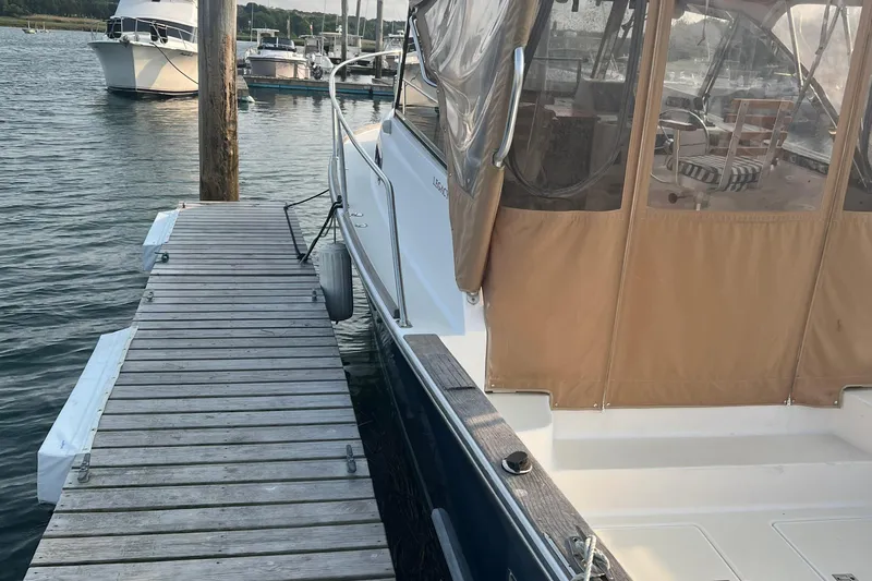Slide: The Image of 2005 Legacy Yachts 28 docked at a marina with a covered cockpit. - 2