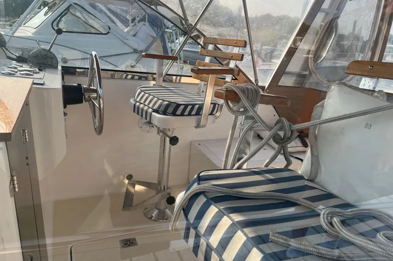 Slide: The Image of Interior of 2005 Legacy Yachts 28 with striped seating and steering wheel. - 7