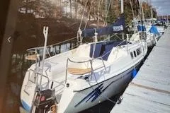 Slide: The Image of 1996 Hunter 23.5 sailboat docked, featuring sleek design and spacious deck. - 2