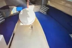 Slide: The Image of Interior of a 1996 Hunter 23.5 sailboat with blue seating and a small table. - 4