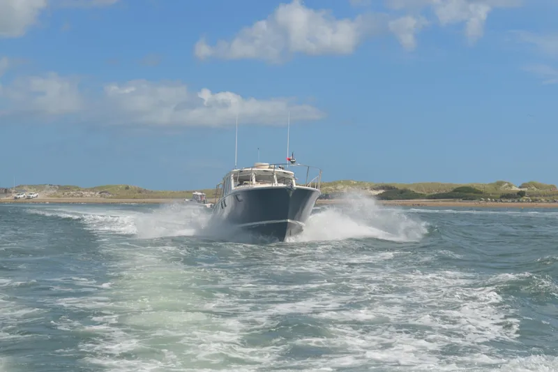 Slide: The Image of MJM 43z 2020 boat cruising on open water under a clear blue sky. - 1