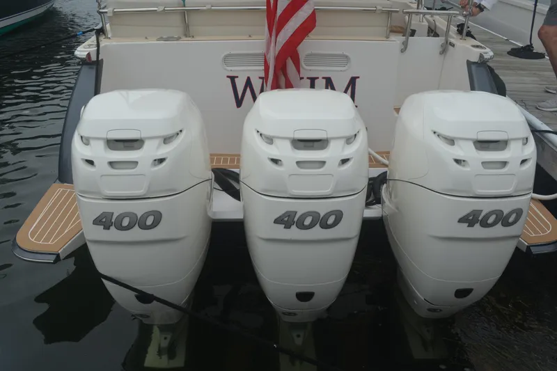 Slide: The Image of Triple 400 horsepower engines on a 2020 MJM 43z boat, docked with American flag. - 11