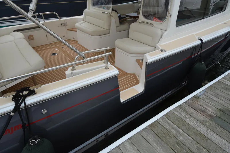 Slide: The Image of 2020 MJM 43z boat interior with cushioned seating and teak flooring. - 12