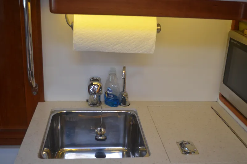 Slide: The Image of Compact kitchen sink area in 2020 MJM 43z boat with paper towel holder. - 33
