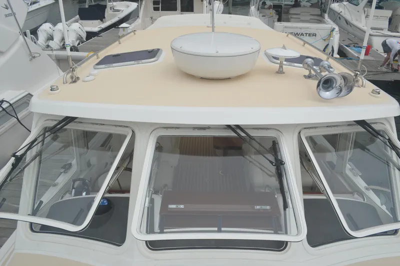 Slide: The Image of 2020 MJM 43z yacht with beige deck and windshield, docked at marina. - 49